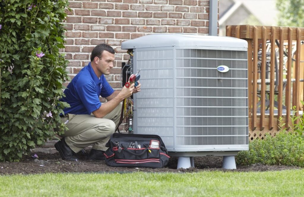 HVAC technician working on air conditioning unit outdoors