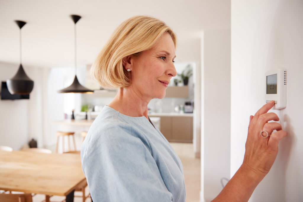 homeowner adjusting thermostat
